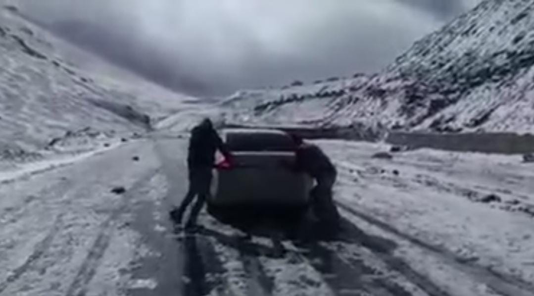 Babusar top road is blocked due to heavy snow fall in Oct- Tourists trying to push their car on babusar top road while it snowfalls