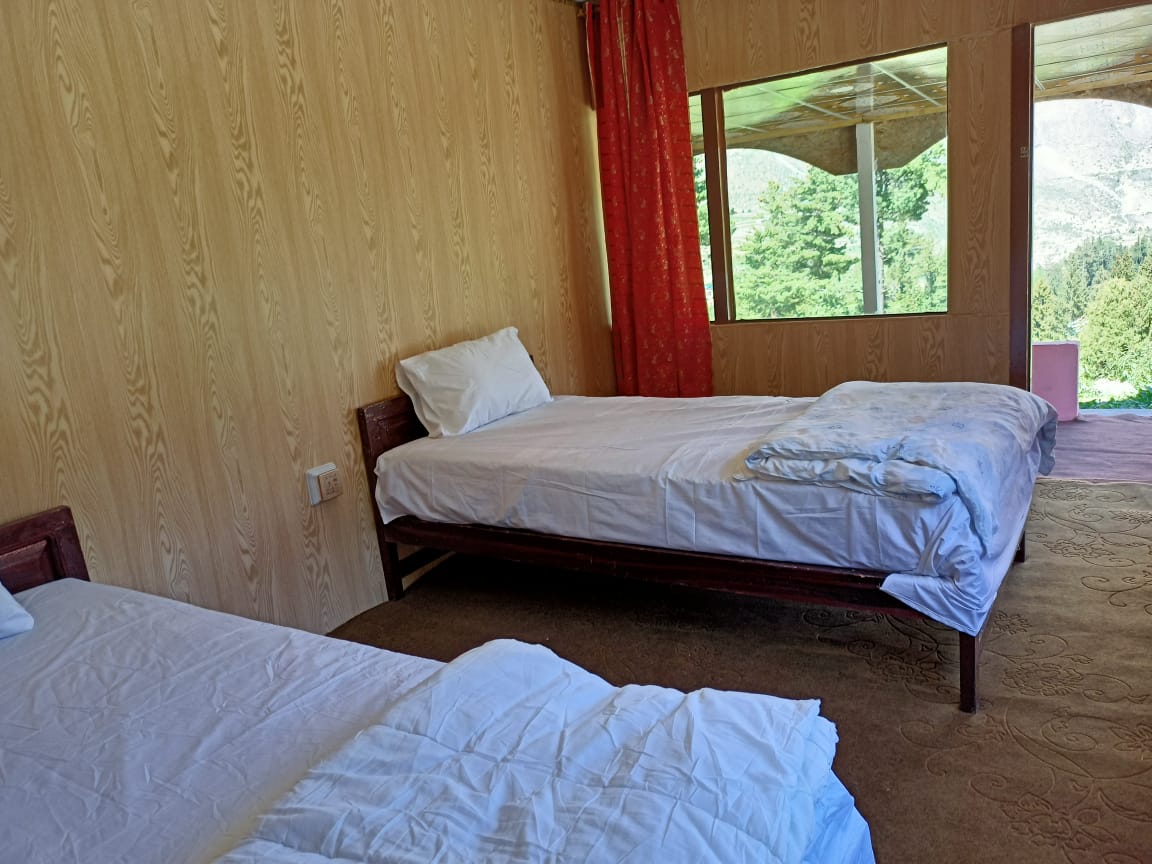 Hotel room in Naltar valley with two beds and view of the valley from windows