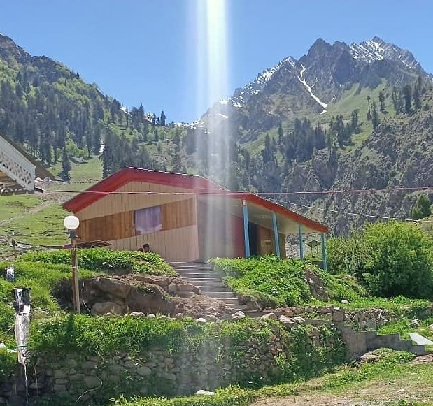 hotel in Naltar valley with lush green mountains in the background